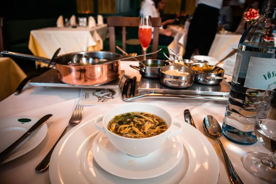 Apollo — A fine dining experience at an upscale restaurant with a beautifully set table and delicious soup.