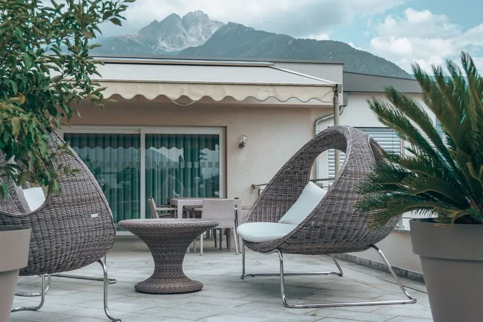 Art Hotel Riposo — Stylish terrace with lounge chairs and nature view, ideal for relaxation and outdoor living.