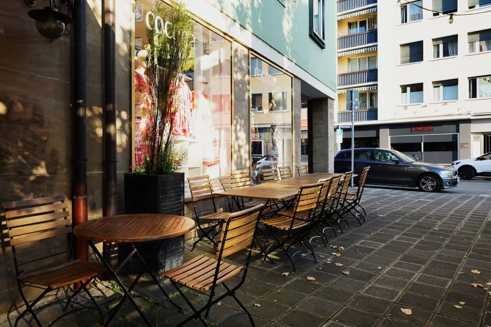 Corso — Charming outdoor café seating in a city setting with natural light and urban surroundings.