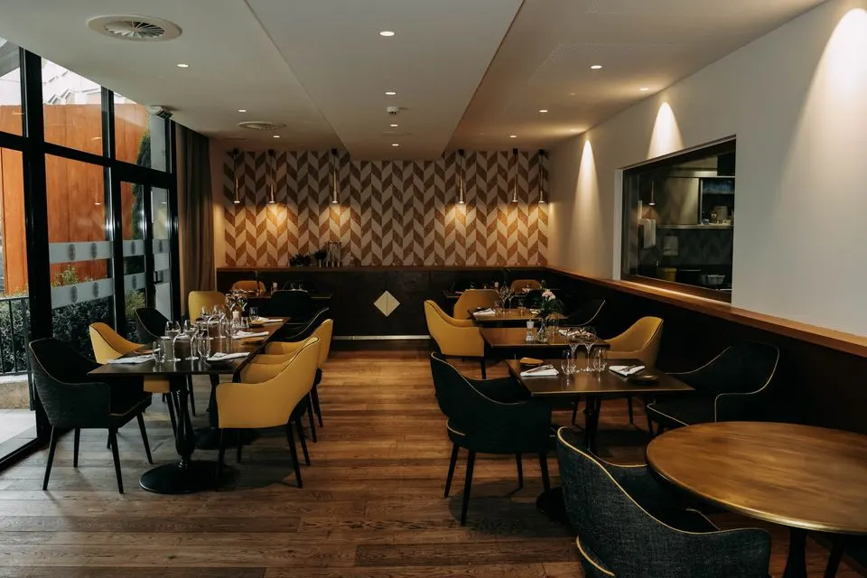 Corso — Stylish restaurant interior featuring modern decor, elegant furniture, and well-set dining tables.
