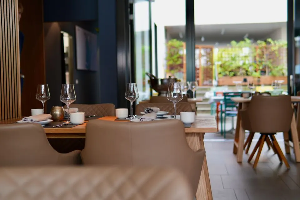 Ecco — Elegant dining room set up with tables and chairs in a cozy restaurant setting.