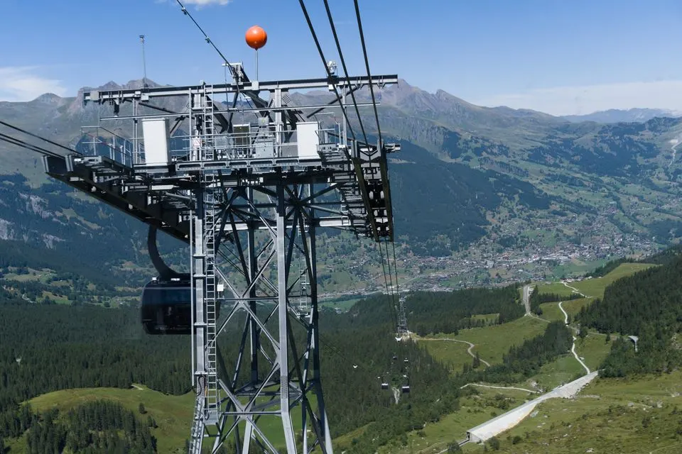 Grindelwald-Maennlichen gondola — Cable car suspended over Swiss Alps offering breathtaking panoramic views.