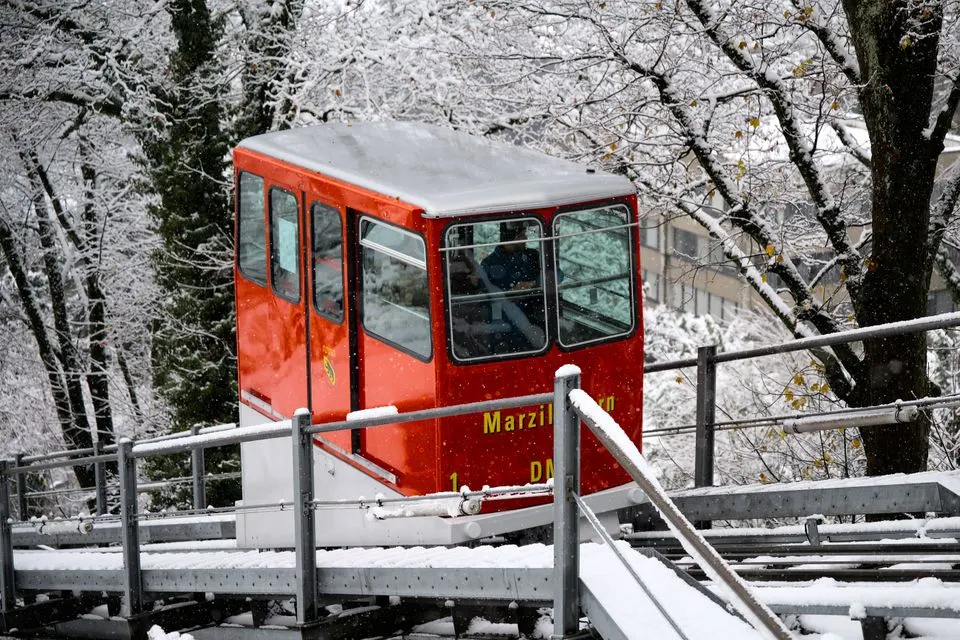 Harder Kulm funicular — Red funicular carriage traveling through a snowy forest in winter.