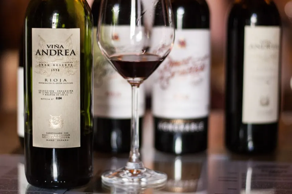 IGNIV by Andreas Caminada — Close-up of Vina Andrea wine bottles in Rioja, Spain, featuring a glass of red wine.