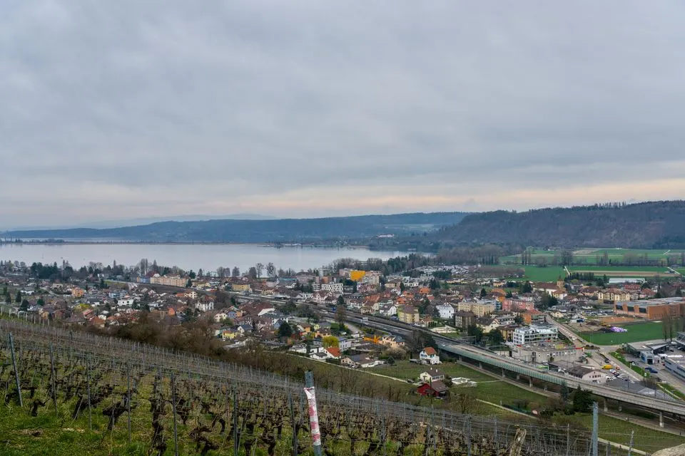 Panoramic view of Nidau, Switzerland, overlooking Lake Biel and surrounding hills.