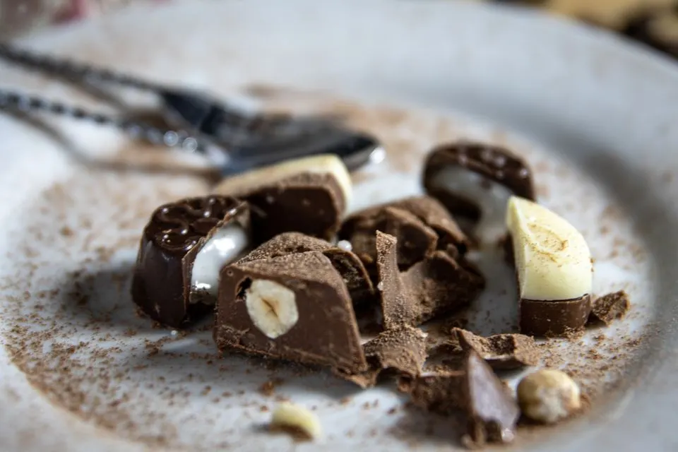 Maison Cailler — An appealing close-up of mixed chocolate pieces on a white plate, showcasing premium confectionery.