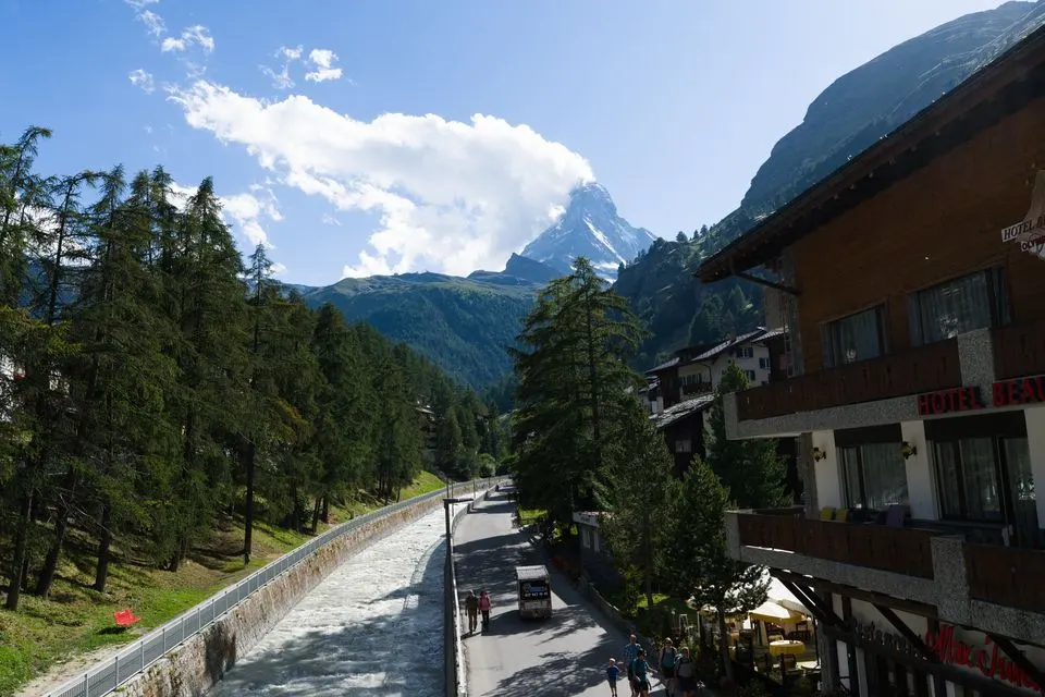 Matterhorn FOCUS — Scenic view of the Matterhorn from Zermatt with alpine architecture and flowing river.