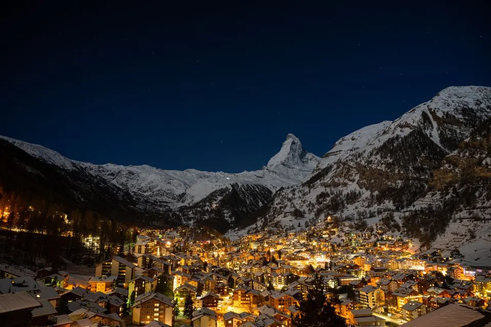 Matterhorn FOCUS — Stunning nightscape of Zermatt with the illuminated Matterhorn and village lights in Switzerland.