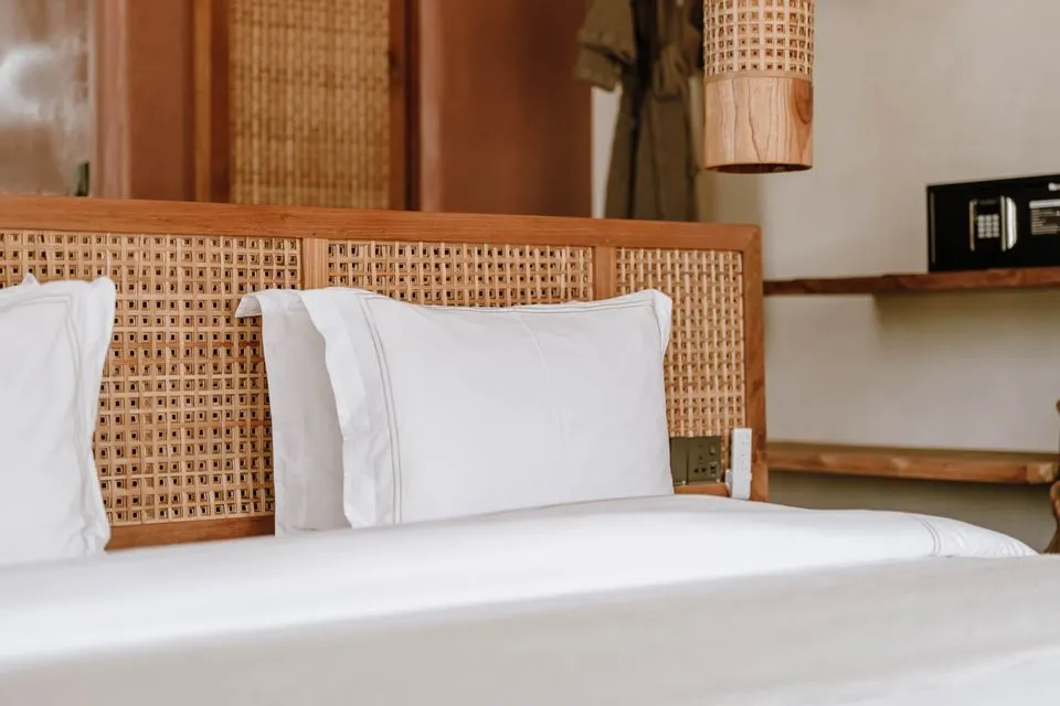 Monte Rosa Boutique Hotel — Elegant boutique hotel room featuring a rattan headboard and soft linens in Jambiani, Tanzania.