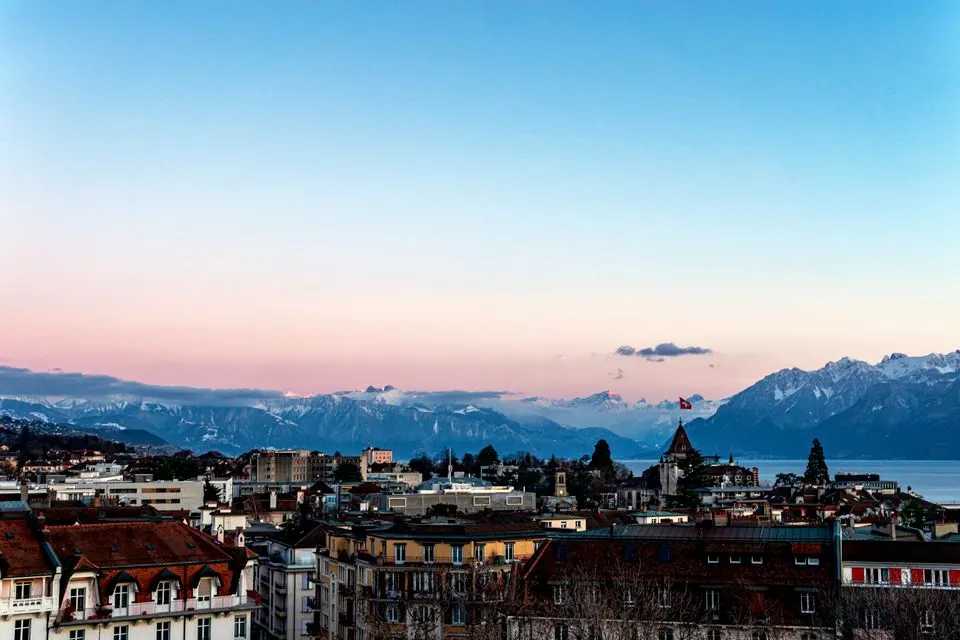 Pic Beau-Rivage Palace — Breathtaking sunset view of Lausanne cityscape with Alps and Lake Geneva in the backdrop.
