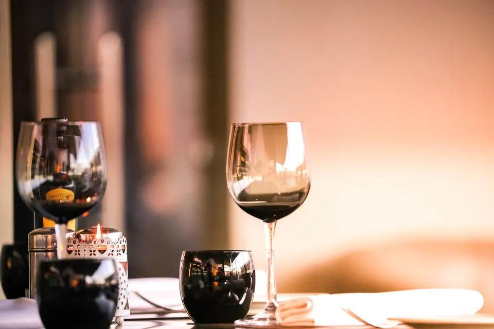 Rosmarin — Elegant setup with wine glasses and a candle, perfect for dining ambiance.