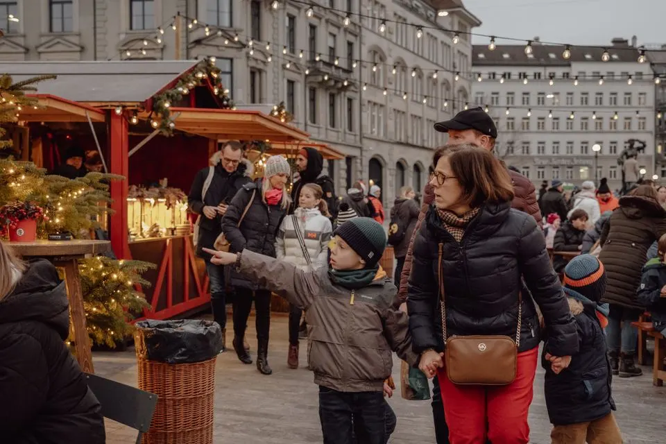 St. Gallen Christmas Market — Family strolls through a festive Christmas market in Zürich, capturing the joy of the winter holidays.