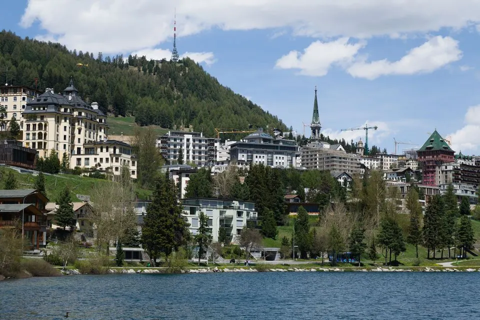 The Crystal Hotel — Captivating view of St. Moritz with alpine architecture and serene lakefront.