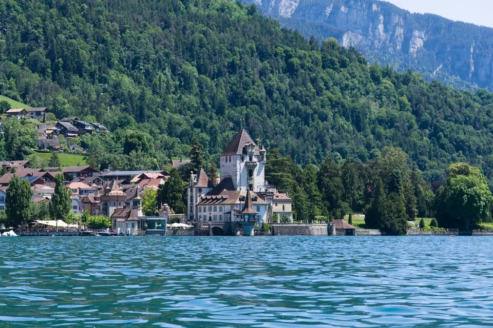 Thun Castle — Picturesque Oberhofen Castle by Lake Thun with lush green hills in Switzerland.
