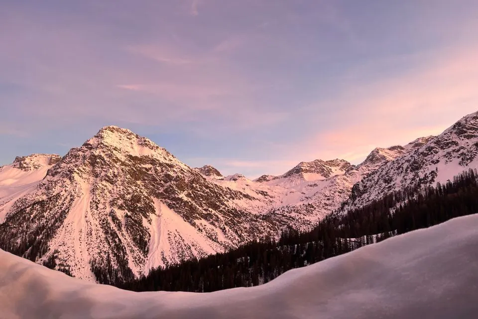 Valsana Hotel Arosa — Magnificent snowy Alps at sunrise in Arosa, Switzerland, showcasing serene winter beauty.